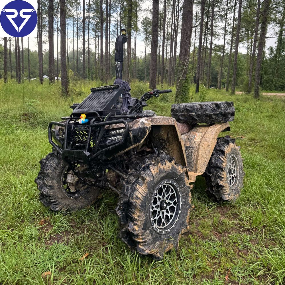Black Honda ATV with mud on tires