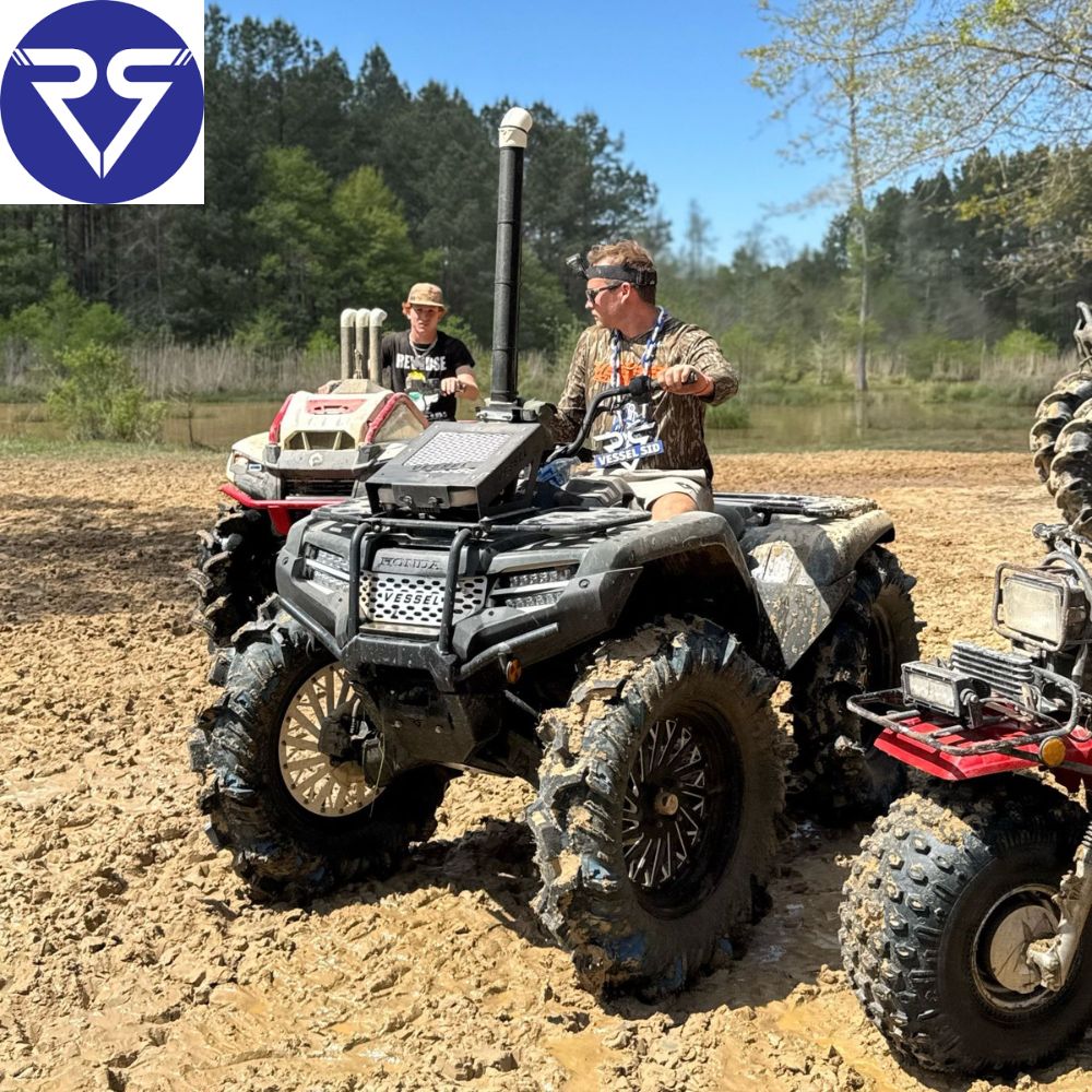 Man riding black Honda ATV on a mud road