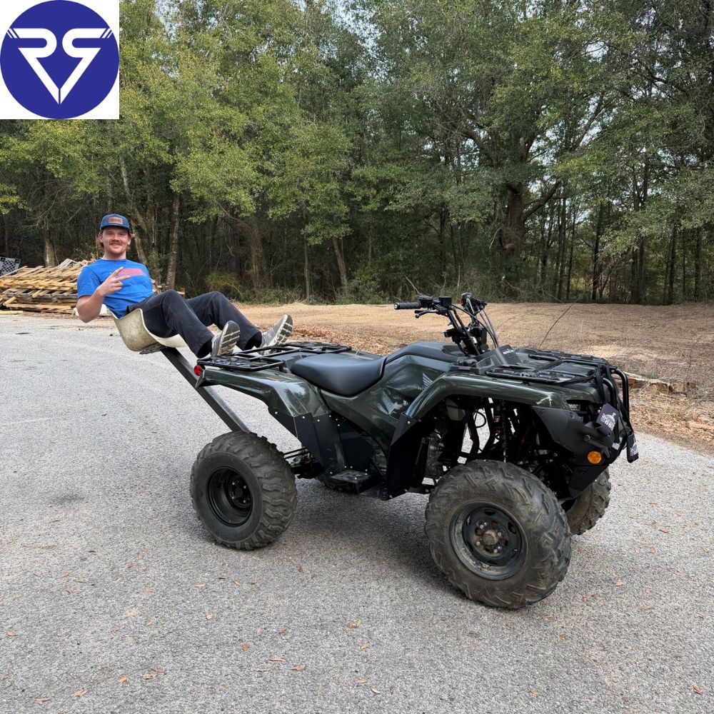Man in blue t-shirt sitting on a black Honda ATV