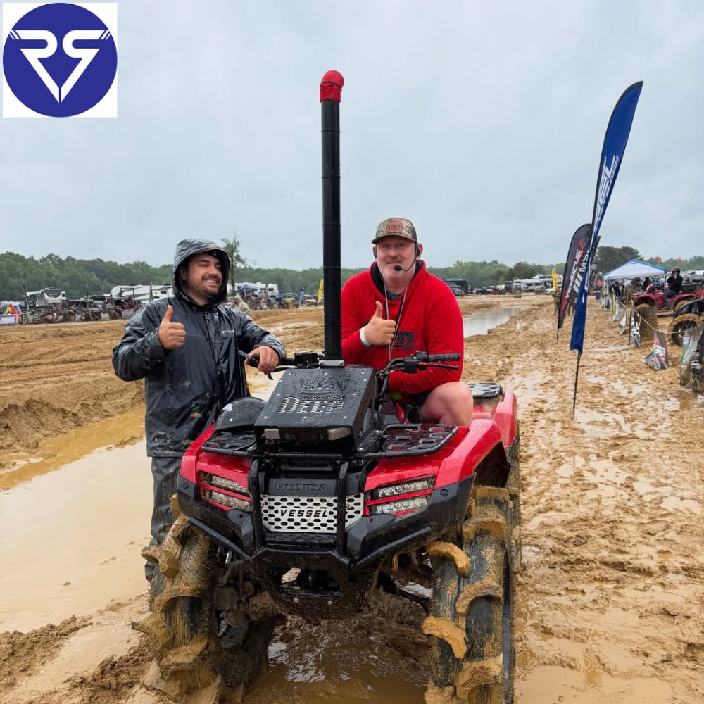 two men posing on red Honda ATV after the trail ride